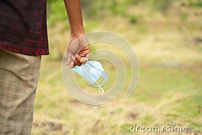 Closeup of hands holding medical mask with copy space - concept of removing mask to feel nature during coronavirus or covid-19 Stock Photo