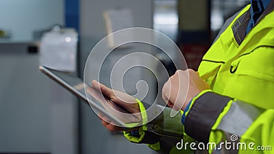 Closeup hands holding tablet computer at modern huge special facility storage. Stock Photo