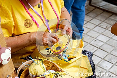 Hands of ladies are demonstrating sewing and decorating of clothes by embroidery frame for students in housework class Stock Photo