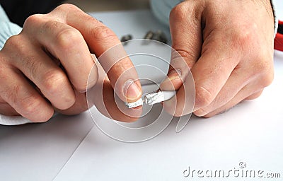 Closeup of hands removing shield from the single professional coaxial cable connector. Stock Photo