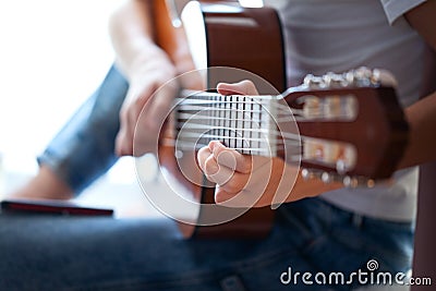 Closeup of hands teenager playing acoustic guitar. Have a hobby. Relaxing boy playing guitar Stock Photo