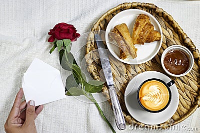 closeup hands woman holding an empty envelope with a tray contains Morning breakfast in bed Stock Photo