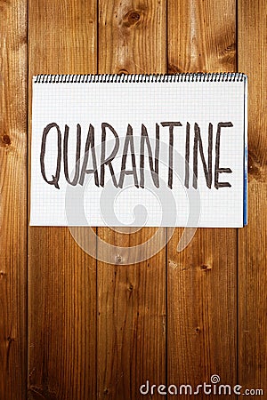 Closeup handwritten warning sign `Quarantine` on wooden wall or door. Stock Photo