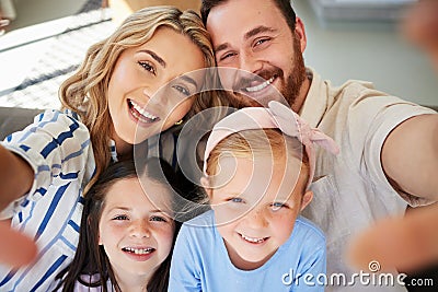 Closeup of happy caucasian family taking selfies at home. Loving parents capturing photos and pictures for special Stock Photo