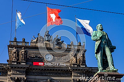 Closeup of the Hauptbahnhof train station building's top part and the monument of Alfred Escher Editorial Stock Photo