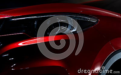 Closeup headlight of shiny red luxury SUV compact car. Elegant electric car technology and business concept. Hybrid auto Stock Photo