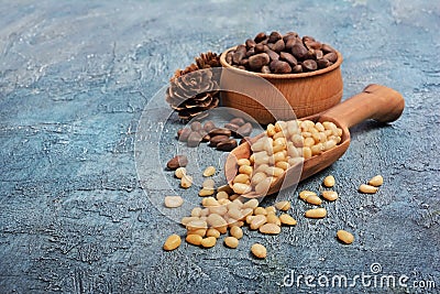 Closeup on healthy and tasty pine nuts in wooden rustic bowl with wood scoop and cedar bump Stock Photo
