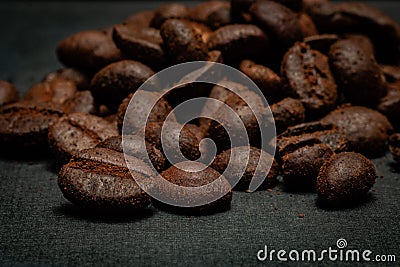 Closeup of a heap of coffee beans on a dark gray surface. Stock Photo