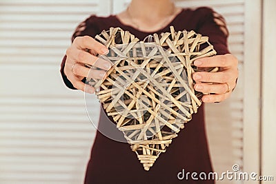 Closeup of heart-shape handmade souvenir show by woman`s hands . The symbol of love forever by heart. Valentine day Stock Photo