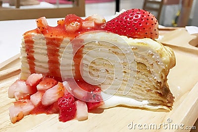 Closeup on Holiday sweet crepe cake with fresh strawberry and whip cream on wooden plate. Stock Photo