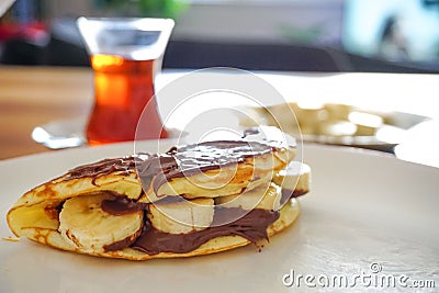 Closeup of homemade pancakes with Nutella hazelnut cream and bananas for breakfast Stock Photo