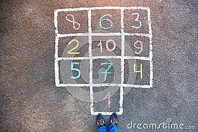 Closeup of hopscotch drawn with chalk on asphalt road. Children Stock Photo