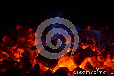 Closeup of hot red embers and blue flame in fireplace Stock Photo