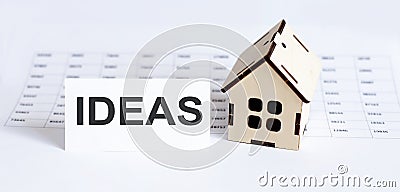 Closeup of house wooden model with blank for text IDEAS on the chart background Stock Photo