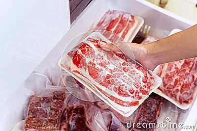 Closeup of human hand picking big chunk red meat Stock Photo