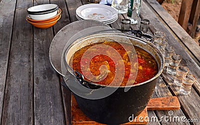 Closeup of a hunting soup of tomatoes and red pepper in a large pan on a wooden table Stock Photo