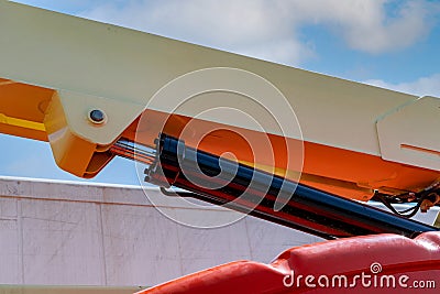 Closeup hydraulic of boom lift. Orange articulated boom lift. Maintenance and repair hydraulic boom lift service. Aerial platform Stock Photo