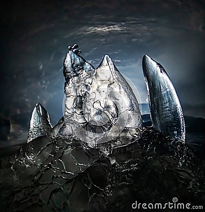 Ice stalagmite in a dark cave Stock Photo