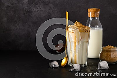 Closeup of Iced Dalgona coffee in glass mug on dark background. Trendy refreshment creamy whipped coffee. Korean coffee Stock Photo