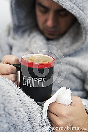 Ill man and mug with word grippe, flu in French Stock Photo