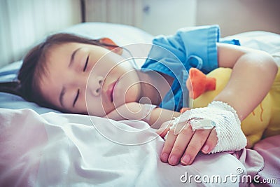 Illness asian child admitted in hospital with saline intravenous Stock Photo