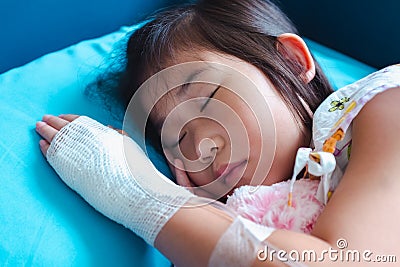 Illness asian child admitted in hospital with saline intravenous on hand Stock Photo