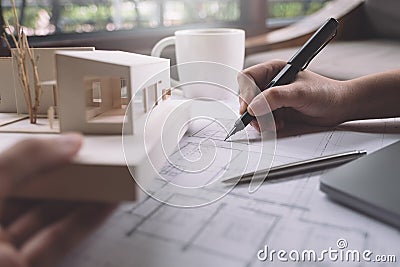 Closeup image of architects drawing shop drawing paper with architecture model Stock Photo