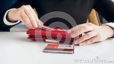 Closeup photo of businesswoman inserting credit card in leather purse Stock Photo