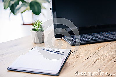 closeup image of empty textbook, pen, potted plant, computer and computer keyboard Stock Photo