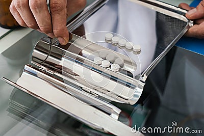 Pharmacist prepare pills in qualified counting tray by prescription at drugstore Stock Photo