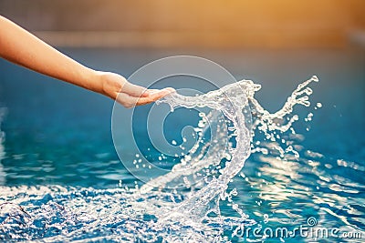 A hand splashing water in the pool Stock Photo