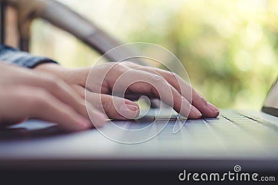 Closeup image of hands working , touching and typing on laptop keyboard with blur nature Stock Photo