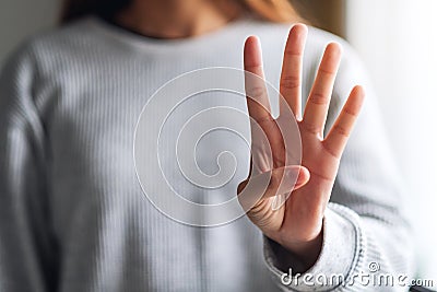 A woman making and showing number four hand sign Stock Photo