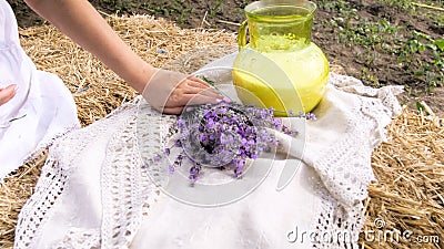 Closeup photo of young woman sitting on farm and holding bunch of lavender flowers Stock Photo