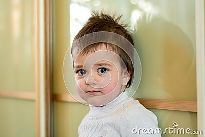 Closeup indoor portrait of a baby boy with naughty hair. The various emotions of a child. Stock Photo