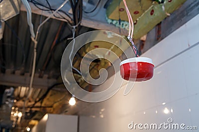 Closeup installation and repair of electric cable, smoke detector, fire alarm system before installing stretch or suspended Stock Photo