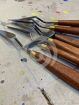 Closeup of isolated spatulas, painting tools on a cardboard background with drops of colored paint on an art lab Stock Photo