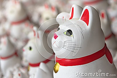 Closeup on a Japanese manekineko cat lucky charm in Buddhist gotokuji temple. Editorial Stock Photo