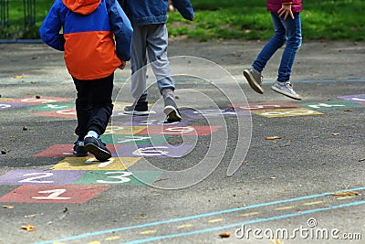 Closeup of kids feet jumping and playing hopscotch at school Stock Photo