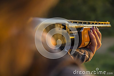 Closeup of lady aiming shotgun Stock Photo