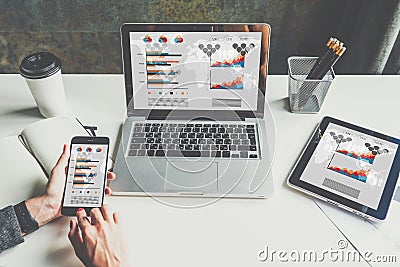 Closeup of laptop and digital tablet with charts, graphs and diagrams on screen. Stock Photo