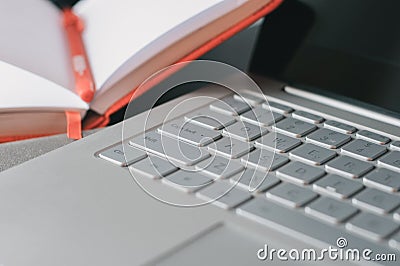 Closeup laptop keyboard and opened notebook Stock Photo