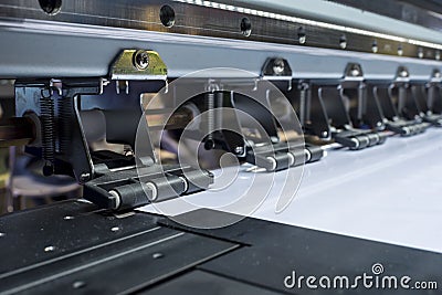 Closeup of a large format tarpaulin printer, showing the anti-static pinch rollers and mute guide rail Stock Photo