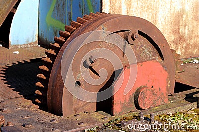 Closeup of large vintage old railway turntable or wheelhouse cogwheel mounted on side of railroad tracks Stock Photo