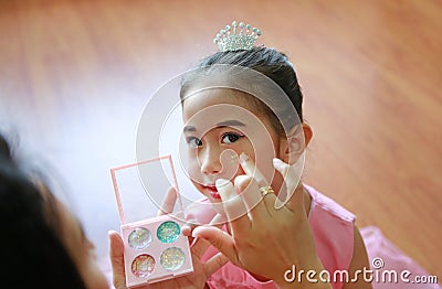 Closeup little Asian ballerina girl with glister makeup by her mother Stock Photo