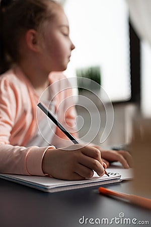 Closeup of little child writing mathematics homework on notebook Stock Photo