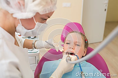 Closeup of little girl opening mouth wide during dental treatment of oral cavity. Stock Photo