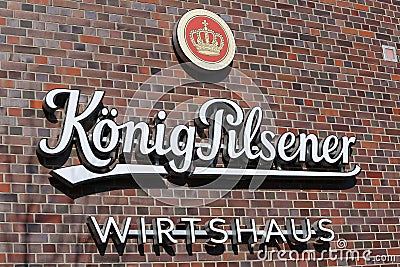 Closeup of logo lettering of german kÃ¶nig pilsener beer brewery at brick wall Editorial Stock Photo