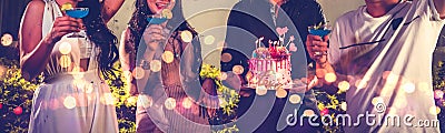 Closeup lower body friends group having outdoor birthday party at night club with birthday cake. Event and anniversary concept. Stock Photo