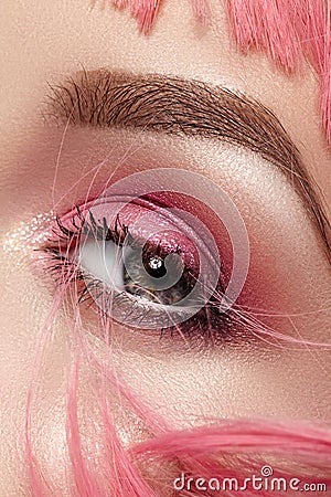 Closeup Macro of Pink Fashion Eye Make-up. Expressive Makeup, Bright Summer Eyeshadows and Magenta Color Hair Stock Photo